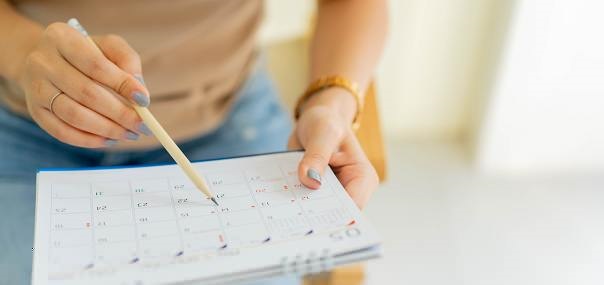 Lady pointing on a calendar with a pen