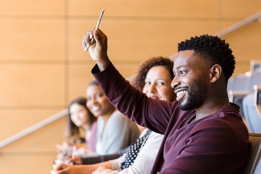 A student raise his hand in a class
