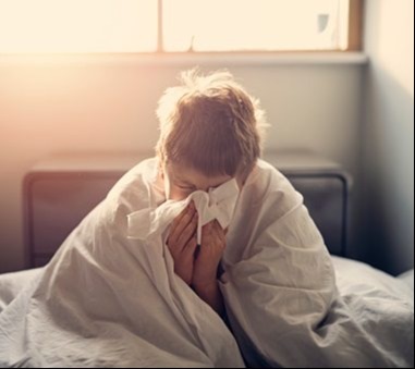Sick child sitting on bed