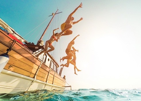 young people jumping from a boat